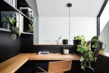 an elegant minimalist home office in grey and black, with open storage units, a stained corner desk and a leather chair plus potted greenery