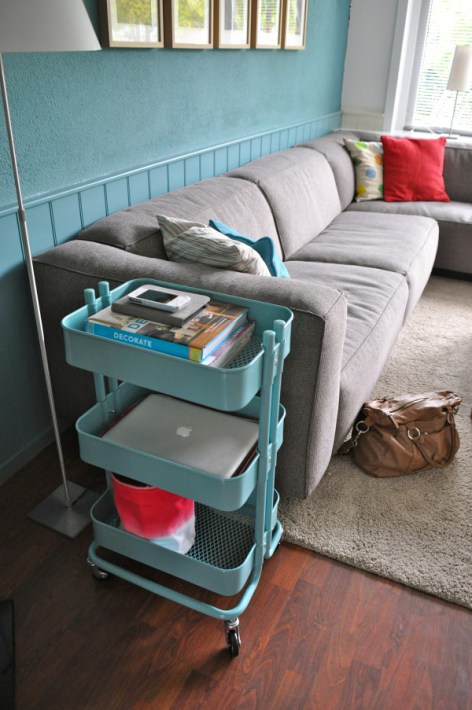 The cart is a great organizer for books and computer devices in a living room.