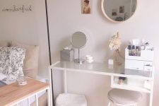 a Vittsjo table turned into a comfortable vanity, with makeup storage, a mirror and a round mirror on the wall, a basket for storage