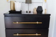 a black IKEA Malm accessorized with large brass handles brings a trendy and chic feel