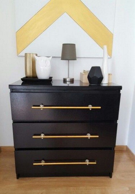 a black IKEA Malm accessorized with large brass handles brings a trendy and chic feel