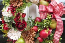 a bold fall wreath of greenery, natural and dried blooms, faux fruit and berries and a bold plaid bow