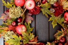 a bright and chic fall wreath of faux foliage, apples, berries, dried hydrangeas, cinnamon sticks will have a fall aroma