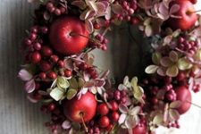a chic fall wreath of dried blooms, berries and red apples is a small and cute decoration for your porch