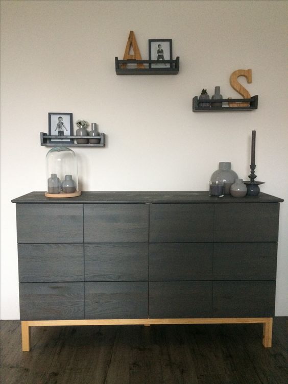 A contemporary IKEA Tarva hack with dark stain, no knobs or handles and a light colored frame and legs