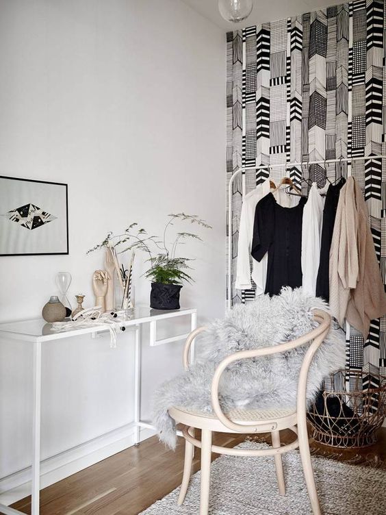 A cozy makeup nook in the walk in closet, with a white Vittsjo desk, a neutral chair, greenery, bulbs and some decor is a lovely space