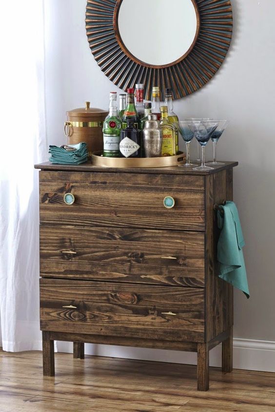 a dark stained IKEA Tarva dresser with thin pulls and turquoise knobs is a stylish piece