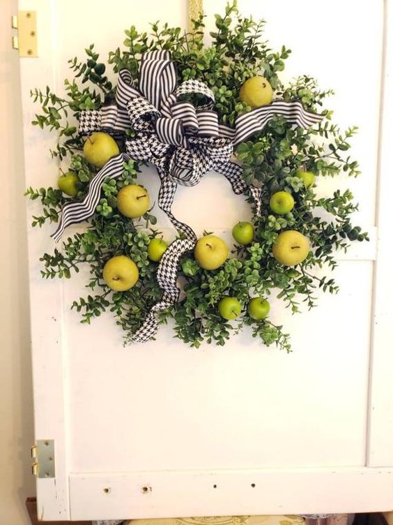 a fun and bright fall wreath of boxwood, green and yellow apples and printed bows for a colorful touch on your door