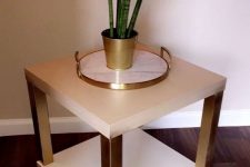 a glam nightstand or plant stand of two IKEA Lack coffee tables with white tabletops and gold legs is shiny and chic