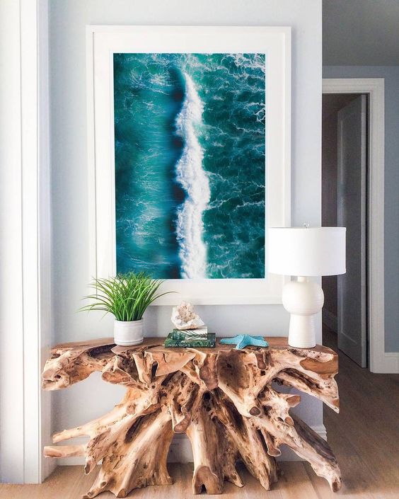 a gorgeous driftwood console table and an ocean print turn the entryway into a fantastic seaside space and they look wow