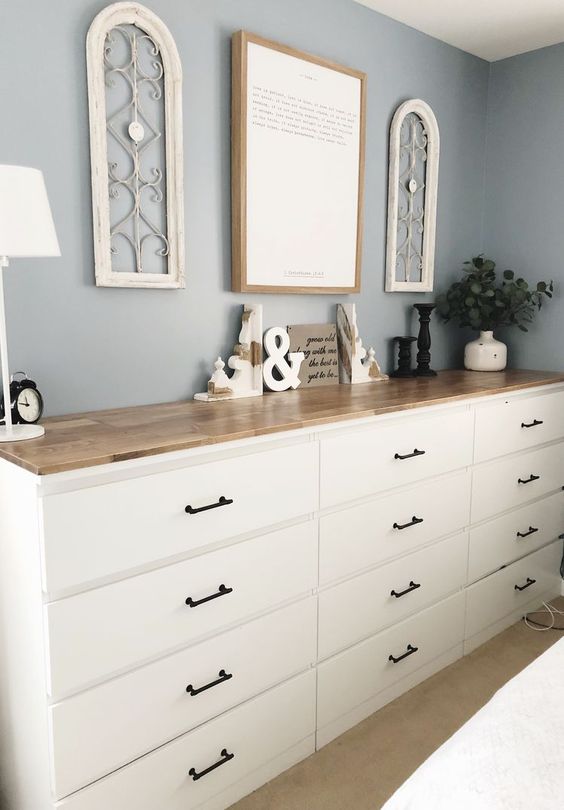 A large sideboard made of several Malm dressers with black handles and a single light stained countertop