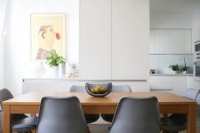a minimalist dining space with a wooden table, grey chairs, white IKEA Ranarp pendant lamps is very cozy