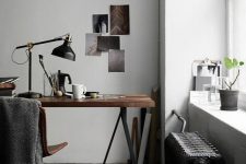 a moody home office nook with a trestle desk, a leather chair, a black radiator and a black IKEA Ranarp table lamp