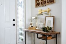 a rustic console table of a Vittsjo desk plus a rough wooden tabletop, a basket for storage, cool art and a table lamp and a board for storing keys