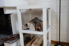 a simple and pretty IKEA Lack table hack – two pieces used to build a single firewood stand by the fireplace, which is a smart solution