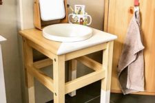 an IKEA Oddvar stool with dipped legs and a color block top as a vanity for a kids’ sink