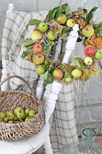 an all-natural fall wreath of real apples, foliage, hay is very rustic and farm-like, with partly dried leaves