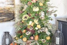 a Thanksgiving tree decorated with ornaments, faux pumpkins, pinecones, faux leaves and foliage is a chic idea