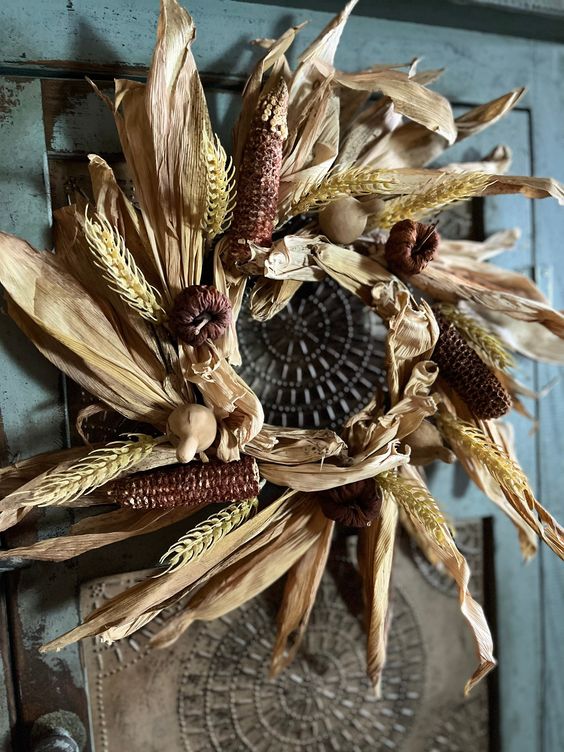 a beautiful rustic fall wreath of corn husks, corn cobsm wheat, little faux pumpkins and gourds looks very cool and unusual
