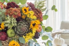 a bold fall centerpiece of yellow, orange and rust and burgundy blooms, greenery, faux apples and pears plus foliage