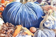 a bright fall centerpiece of blue velvet pumpkins, white and blue usual ones, pinecones and berries, acorns and husks
