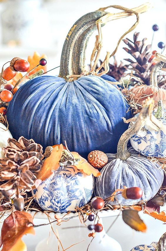 a bright fall centerpiece of blue velvet pumpkins, white and blue usual ones, pinecones and berries, acorns and husks