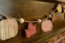 a bright rustic fall garland with wooden beams and wooden plaques styled as pumpkins and leaves is a lovely solution