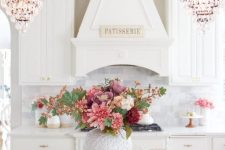 a chic monochromatic floral centerpiece of pink, dusty pink, burgundy and white blooms and greenery for the fall