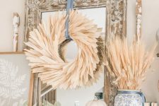 a classy and very elegant corn husk wreath with a blue ribbon is a great solution for more formal and vintage spaces
