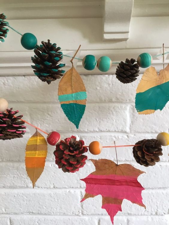 a colorful fall garland of bright beads, leaves and pinecones is a cool idea to decorate a colorful fall or Thanksgiving space