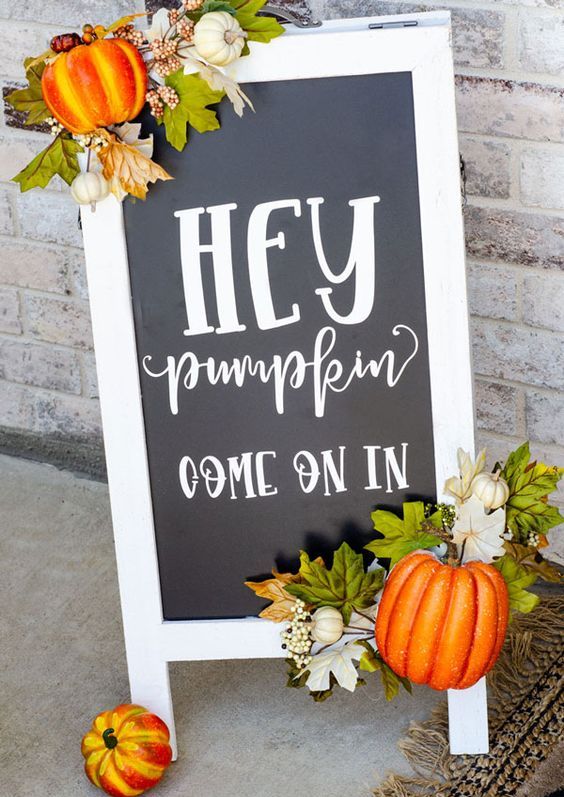 a cool black and white fall sign decorated with faux leaves ad pumpkins is a cool fall decoration for outdoors