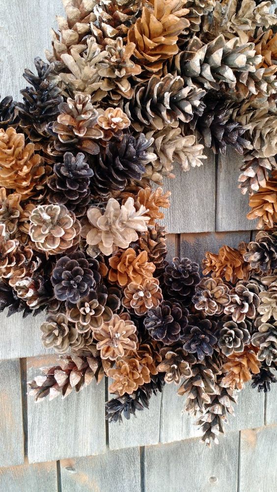 a cool wreath of pinecones of various shades is a very cool fall to winter decoration for your front door