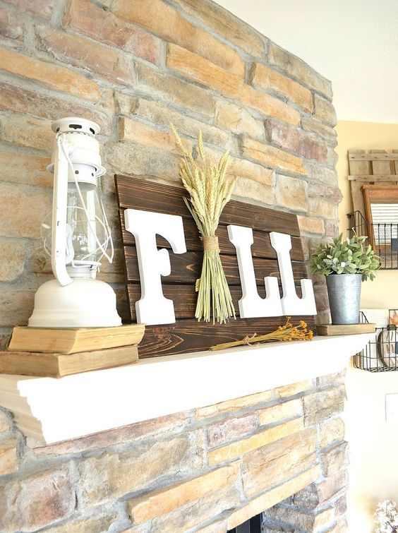 a dark stained Fall sign with white letters and a pack of wheat right in the center for a rustic touch