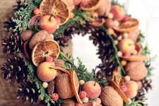 a fall to winter wreath with evergreens, pinecones, nuts, faux apples and berries is a lovely idea