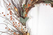 a fall twig wreath with berries, leaves, dried blooms is easy to make and it looks elegant