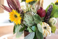 a farmhouse centerpiece of faux blooms, husks, veggies and some foliage is a cool fall decor idea