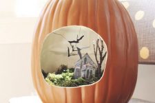 a faux pumpkin with a Halloween scene – moss, a mini house, tree and blackbirds for Halloween
