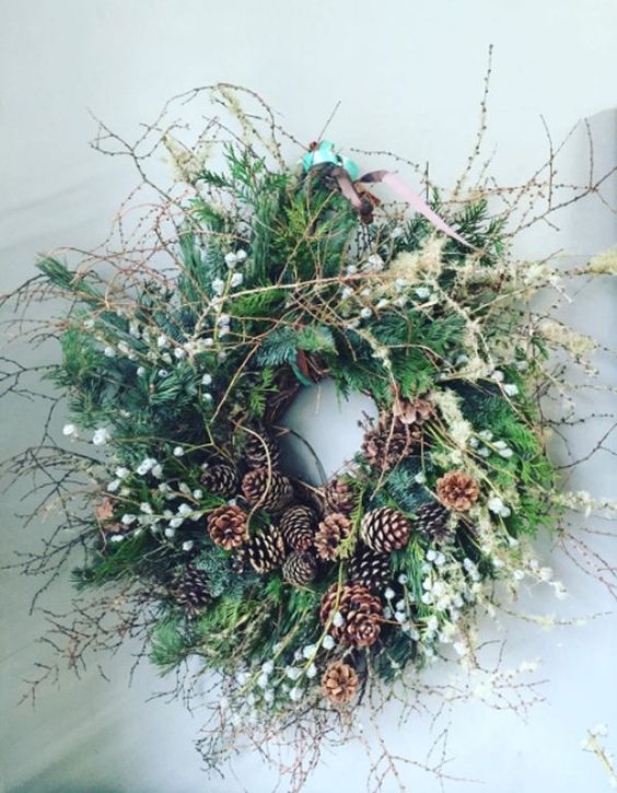 a gorgeous greenery twig fall wreath with berries, pinecones, dried grasses is very woodland-like and boho-like