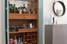 a light blue home bar cabinet with open shelves and a tray plus a mirror backsplash is a stylish idea