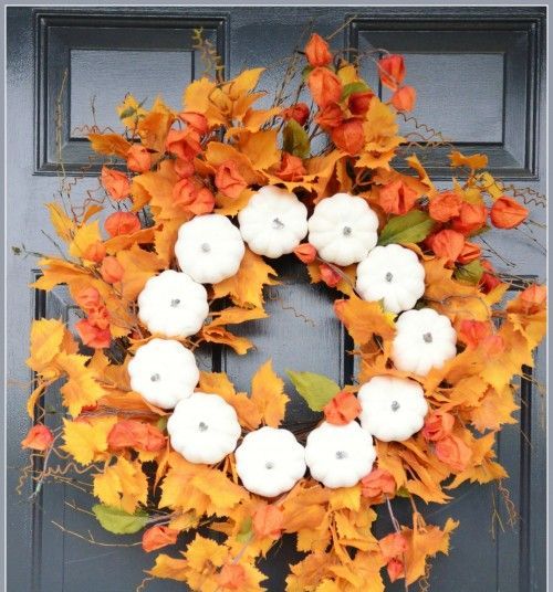 a lush fall wreath of faux leaves, dried blooms and faux pumpkins is a lovely fall decoration for your front door