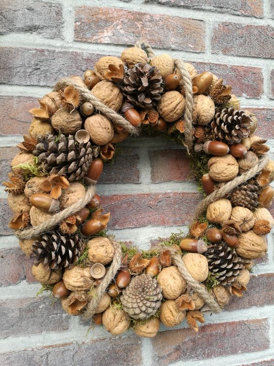 a natural rustic wreath of nuts and acorns, pinecones and rope plus some moss is a cool and chic idea for the fall