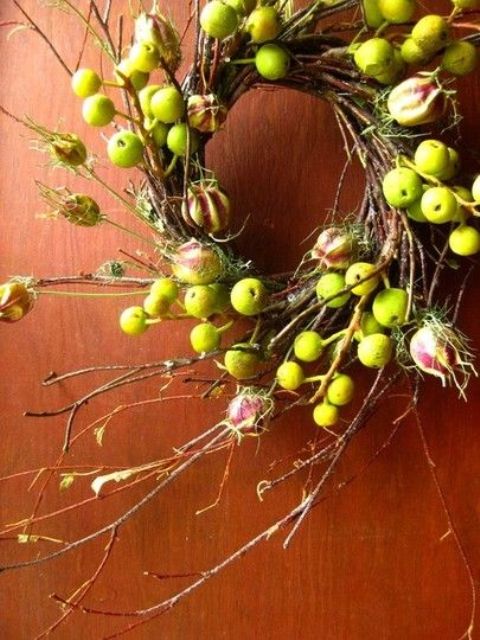 a simple and cool fall twig and branch wreath with lots of apples and blooms plus some moss