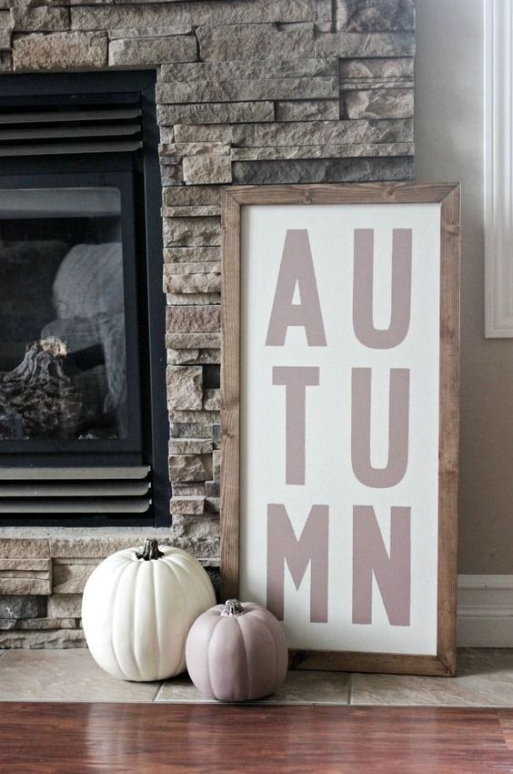 a simple contemporary sign in a stained wooden frame and a duo of pumpkins in such colors