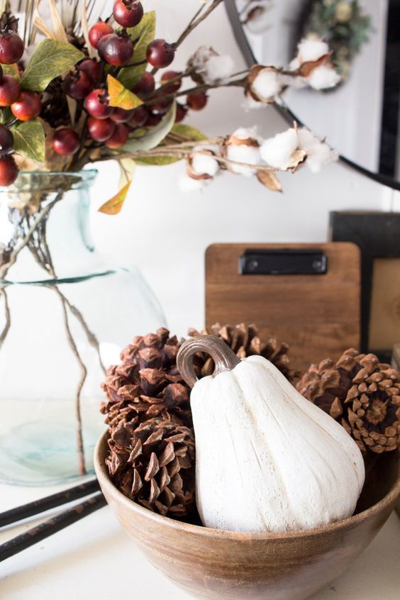 A simple fall centerpiece of a wooden bowl with large pumpkins and a white gourd is a cool all natural idea