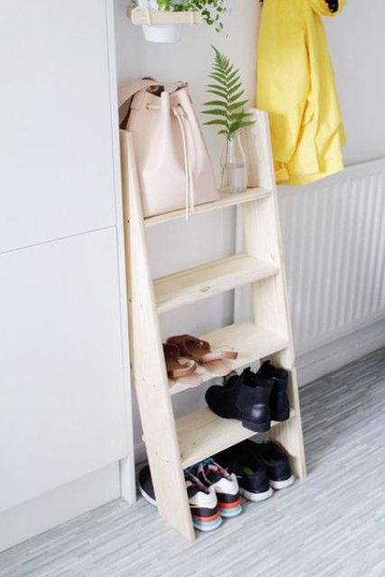 a small wooden ladder used as a shelf for shoes and bags is a simple idea for a bedroom or entryway
