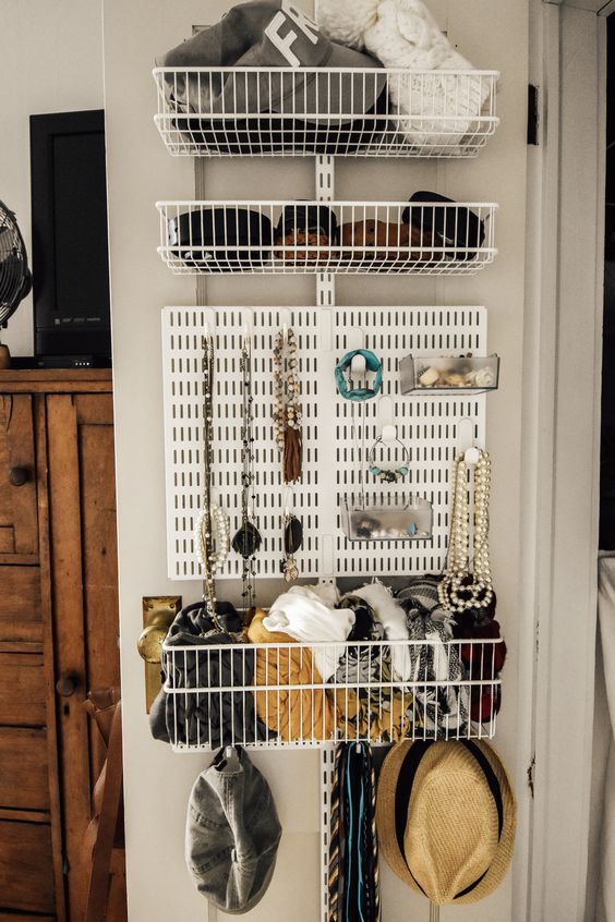 a smart organizer and storage unit attached to the closet door - wire baskets and a board for jewelry are a cool way to organize