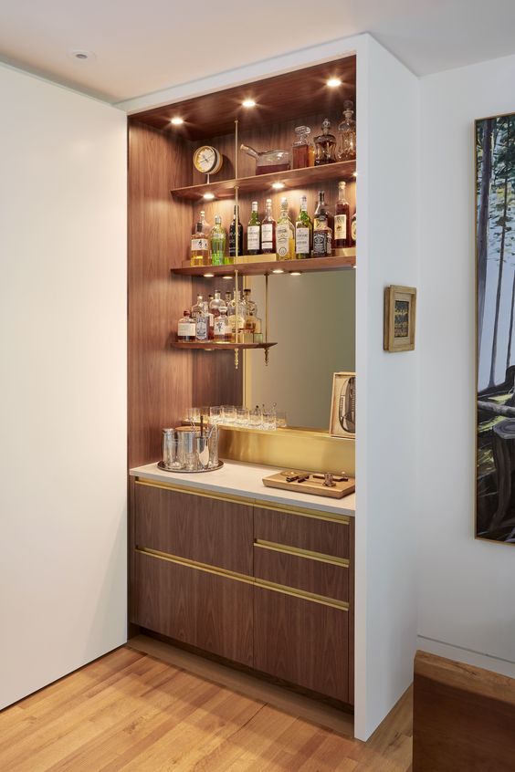 A stylish built in bar with open shelves, a mirror, sleek drawers and lights is a cool and chic idea