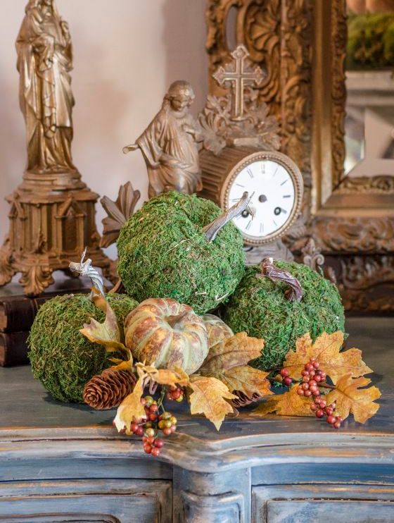 a stylish rustic fall arrangement of moss pumpkins, faux leaves, pumpkins of plastic, berries and pinecones for a woodland or rustic feel
