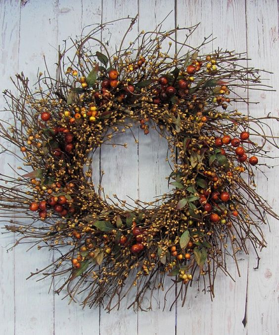 a textural twig fall wreath with foliage, berries and blooming branches is a cool fall decoration