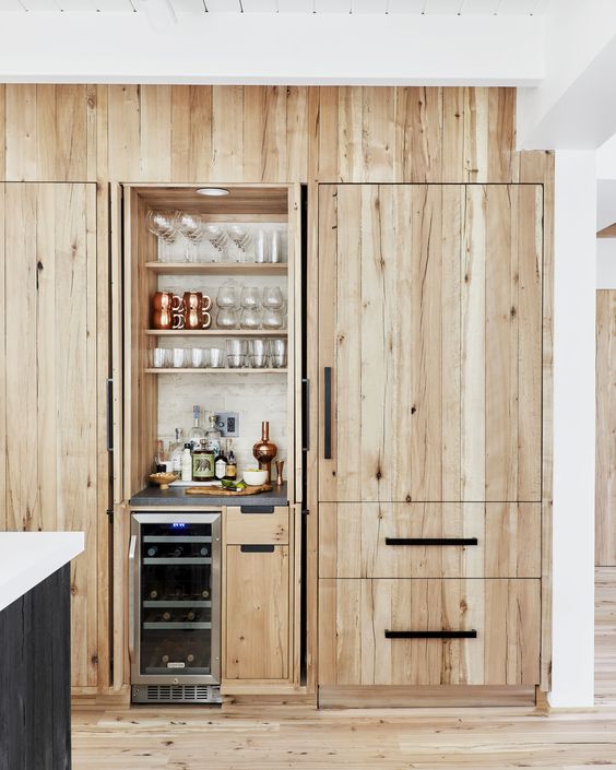 A tiny built in bar with open shelves, a fridge and drawers with everything necessary looks natural in the kitchen
